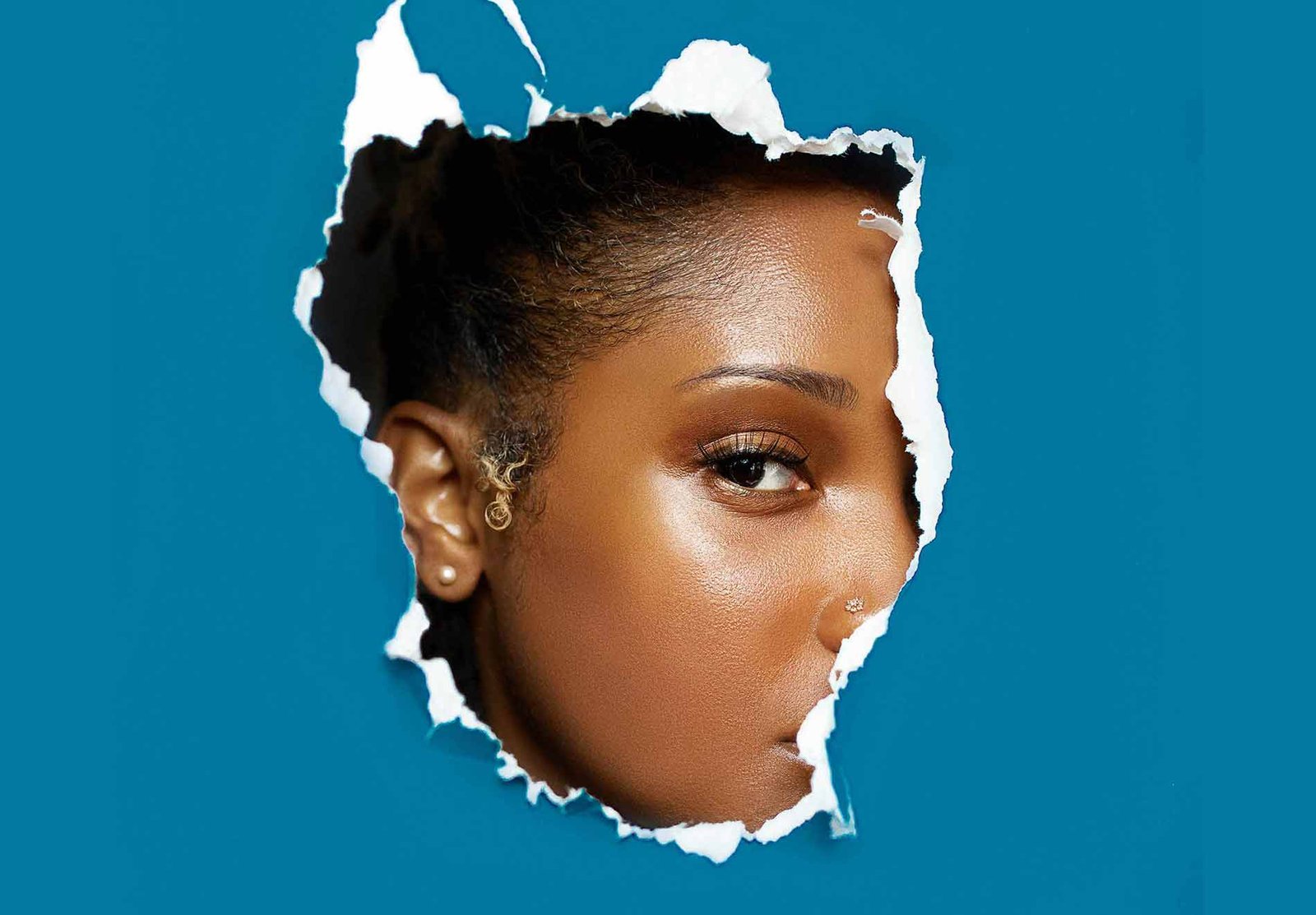 Woman Revealing Her Face through Ripped Paper